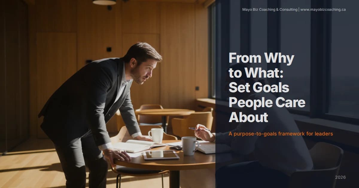 Business leader and team member reviewing goals together in a modern office with warm natural lighting